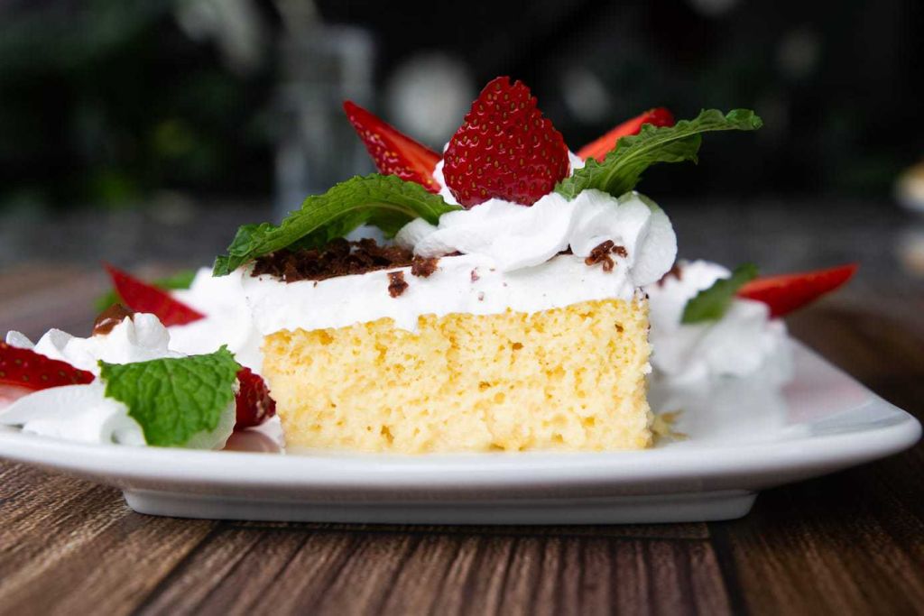 cross section of costa rican moist cake topped with strawberries and mint
